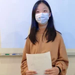 A girl holding a paper with both hands